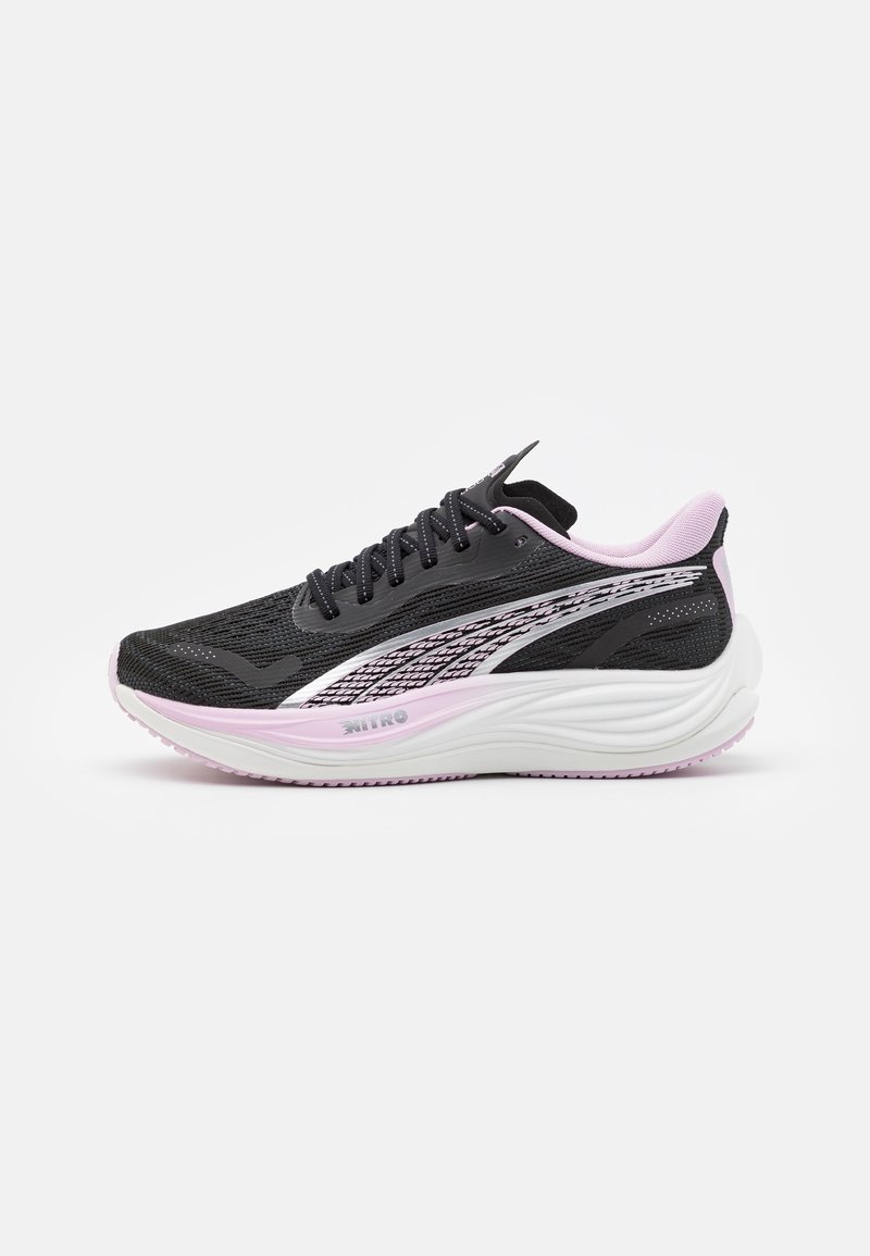 Chaussure de course noire et rose avec une épaisse semelle blanche et rose, tige en maille texturée et rayure latérale à motif sur fond blanc.
