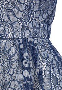 Marineblaues Spitzenmaterial mit floralen Mustern und einem schichtigen Design, das über intricate Details und ein weiches, darunterliegendes Material verfügt.