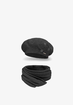 Beret din lână neagră cu embellismente florale circulare și eșarfă eternă asortată. Ambele sunt moi și texturate, ideale pentru vreme mai rece.