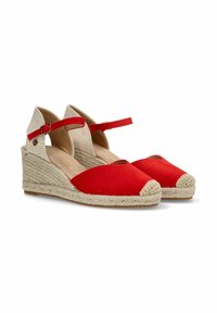 Esparadrapos de tela roja con cuñas de yute tejido, punta redondeada y tiras en el tobillo. Plantilla de color marrón claro y patrón a cuadros beige en el tacón.