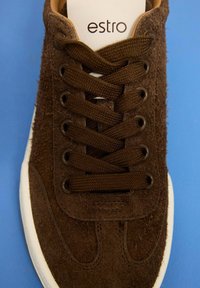 Brązowe zamszowe sneakersy z okrągłym noskiem, materiałowymi sznurówkami i gumową podeszwą. Logo na wkładce, fakturowana cholewka i wzmocnione oczka.