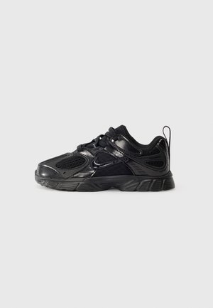 Baskets de sport noires avec empiècements en mesh et synthétiques, fermeture à lacets, languette au talon et semelle en caoutchouc détaillée sur un fond uni.