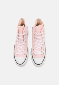 Pink high-top sneakers with canvas material, white laces, black rubber sole, and toe cap; features silver eyelets and stitching accents.