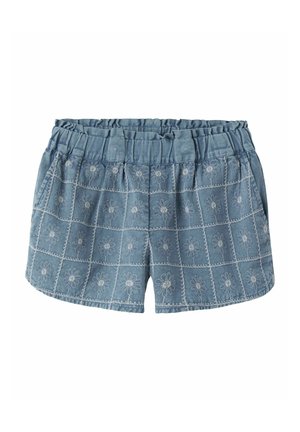 Short en jean bleu avec taille élastique, poches avant et motifs de marguerites blanches brodées disposés en grille sur le tissu.