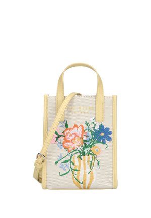 Petit sac fourre-tout beige avec bordure jaune, fleurs colorées brodées dans un vase rayé, et bandoulière ajustable.