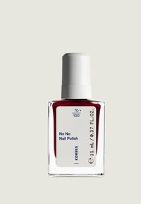Röd nagellack i en klar glasflaska med ett vitt lock. Etiketten har blå text som säger "No No Nail Polish" och produktinformation.