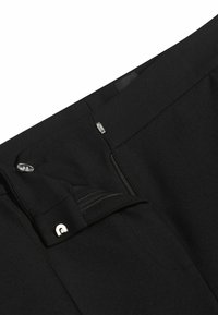 Zwarte broek met een ritszak, knoopsluiting en een gestructureerde stof. Metallica accenten versterken het verfijnde ontwerp.