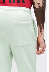 Βαμβακερές φόρμες σε μέντα πράσινο χρώμα με πίσω τσέπη και απαλό ύφασμα, σχεδιασμένες με ορατή ελαστική μέση.