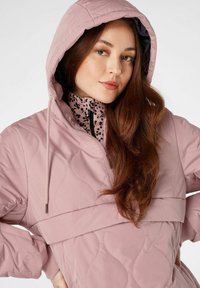 Roze gewatteerde jas met een capuchon, voorzien van een hoge kraag en een zwart-roze patroon aan de binnenkant. Gladde textuur met een getailleerde taille.