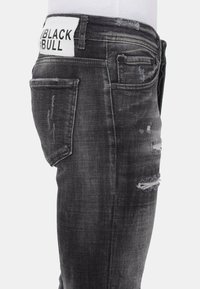 Zwarte spijkerbroeken van denim met een vervaagde look, verwerkte details en een wit label aan de achterkant. Met een slim fit en een klassiek vijf-pocket ontwerp.