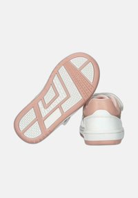 Sneaker bianche con superficie liscia e dettagli rosa. La suola presenta una grip a disegno per una migliore aderenza. Chiusura con strap in velcro.