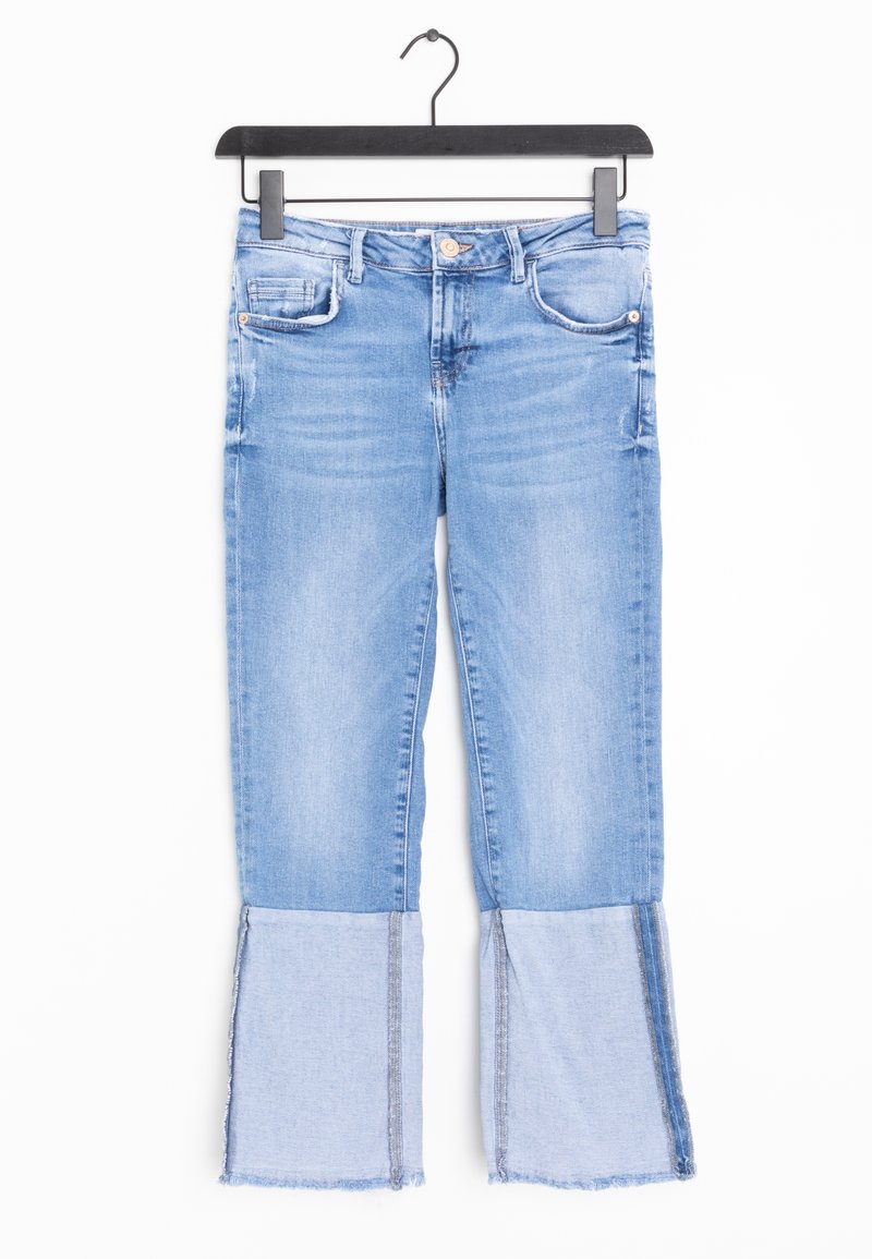 Jean en denim bleu clair avec larges revers à ourlet brut, design cinq poches et fermeture par bouton, suspendu sur un cintre noir.