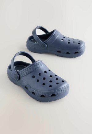 Granatowe chodaki wykonane z lekkiego plastiku, z tylnym paskiem, dużymi otworami wentylacyjnymi oraz teksturowanym wykończeniem na pasku i podeszwie.