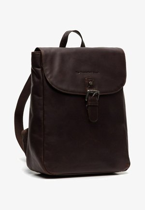 Sac à dos en cuir marron avec une fermeture à rabat, une boucle en métal et des bretelles en tissu réglables ; texture lisse avec un logo en relief sur le devant.