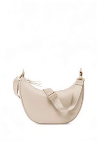 Beige nahkainen olkalaukku, jossa on kaareva muoto, kullanväriset metalliosat ja leveä hihna, jossa on brändäys. Hienovaraiset sivutasselit lisäävät yksityiskohtia.