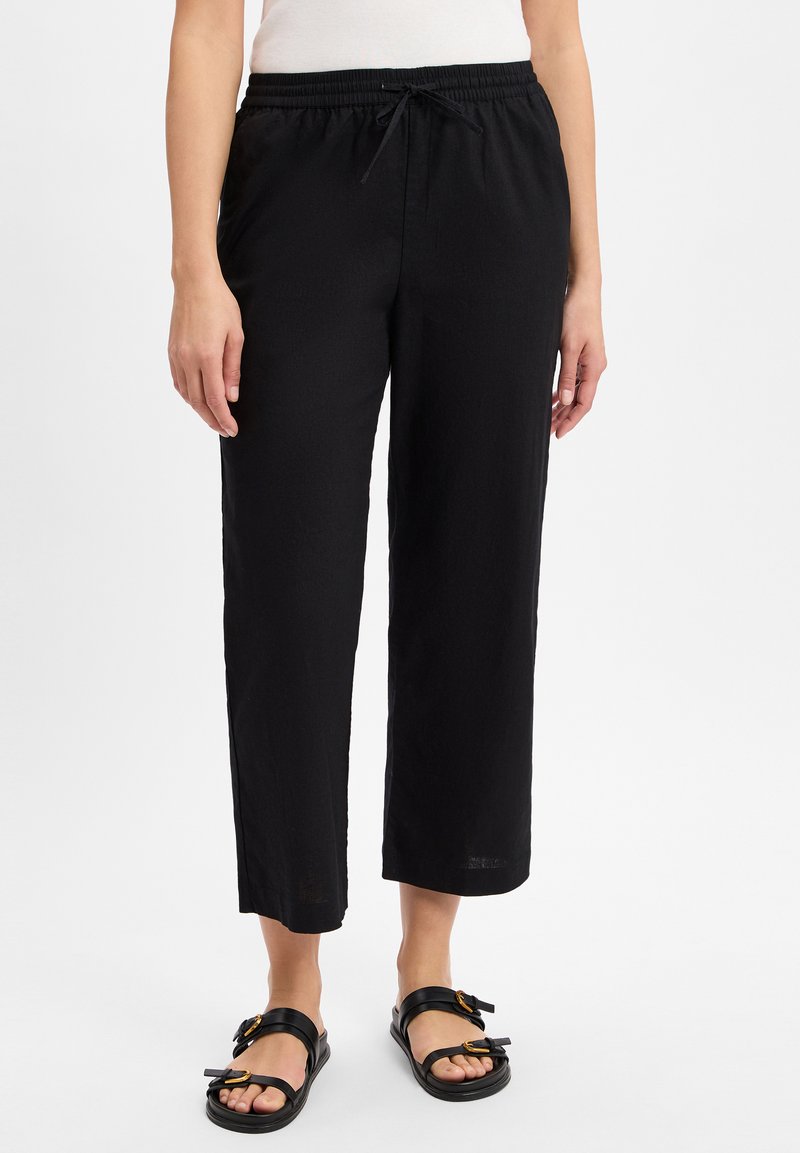 Schwarze, leichte, locker sitzende Hosen mit elastischem Bund und Kordelzug. Kurz geschnitten mit glatter Textur und ohne sichtbare Muster.
