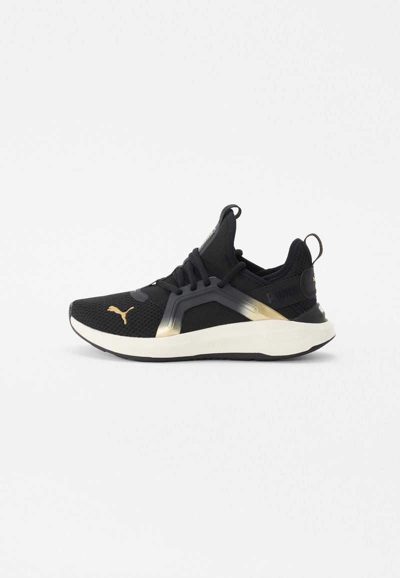 Sort atletisk sneakers med mesh-overdel, gyldne accenter og en polstret hvid sål. Har et struktureret overlay og snøresystem.