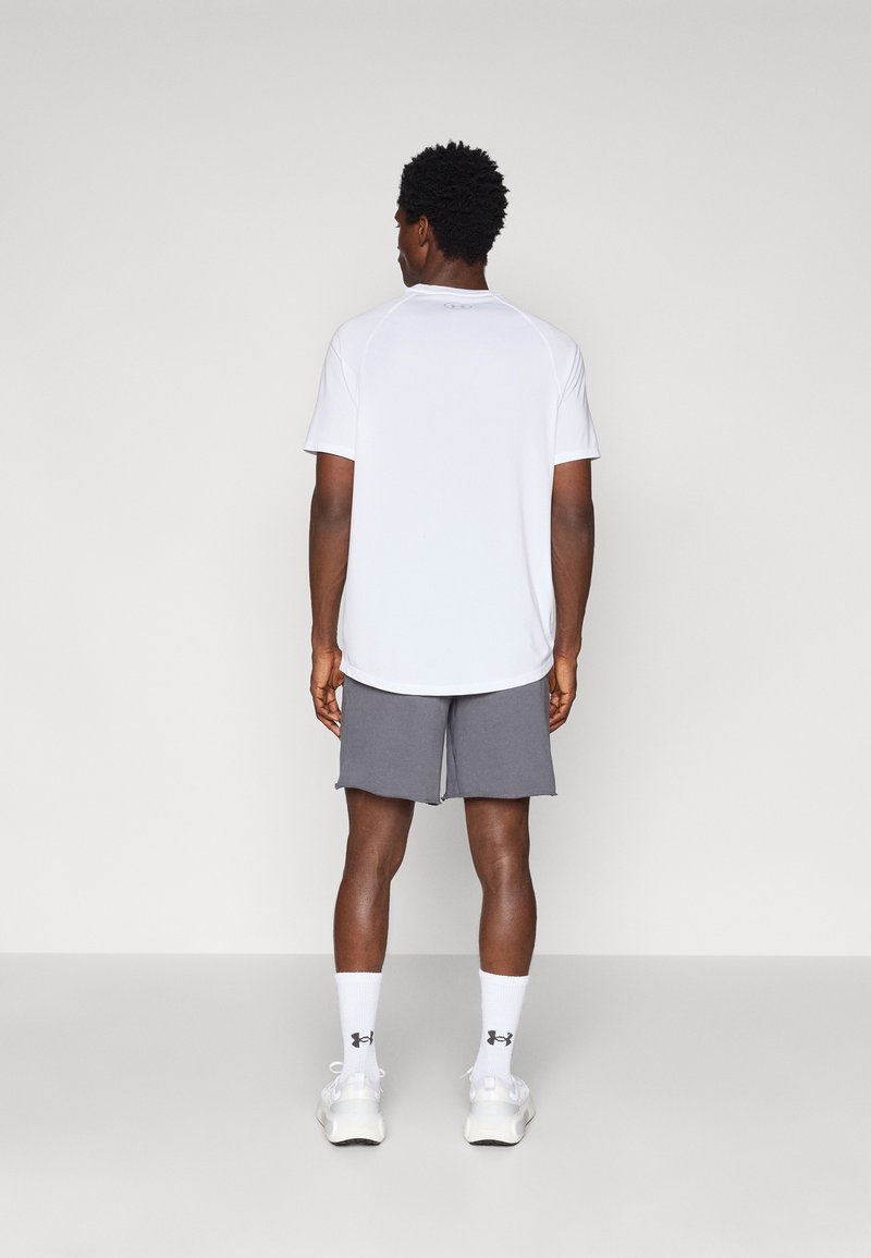 Weißes kurzärmliges Sportshirt und graue Shorts, beide aus leichtem Material. Weiße Socken mit Logo und sportliche Schuhe runden das Outfit ab.