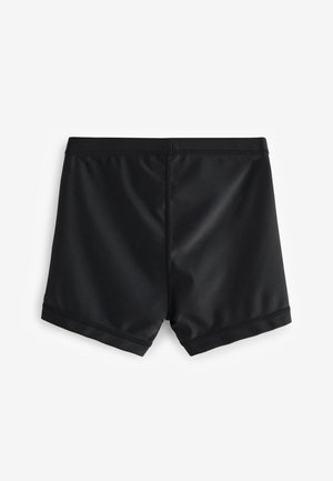 Costumi da bagno neri realizzati in un tessuto liscio e elasticizzato. Presentano un design semplice, una vita senza cuciture e una lunghezza delle gambe corta.