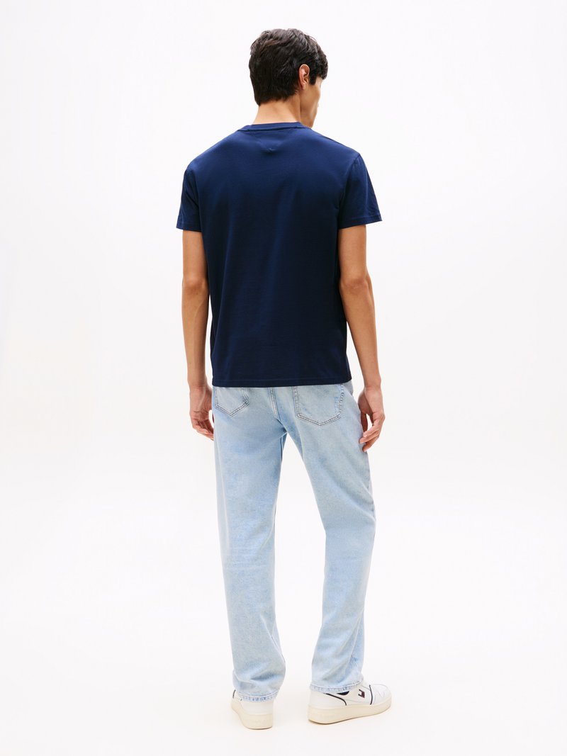 Marineblaue Baumwoll-T-Shirt mit Rundhalsausschnitt. Getragen mit hellblauen Jeans. Der Stoff scheint weich zu sein, ohne sichtbare Muster oder Grafiken.