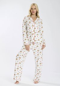 Set di pigiama bianco con stampa floreale e di animali dei cartoon. Include una maglietta a maniche lunghe con rifiniture rosse e pantaloni abbinati in tessuto morbido.