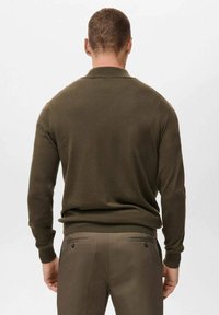 Suéter de punto verde oliva con cuello redondo y puños acanalados, combinado con pantalones a juego. Diseño simple y ajustado con textura suave.