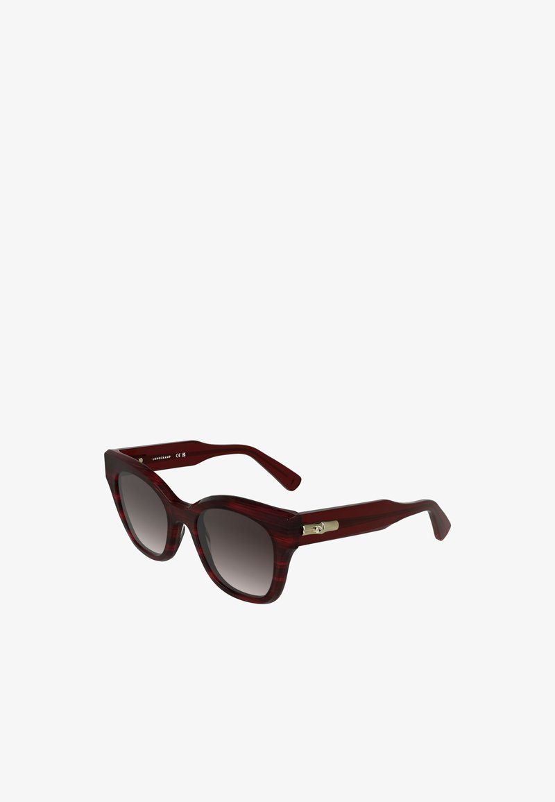 Oogvormige zonnebril met een bordeaux tortoiseprint, vervaagde grijze lenzen en details in goudkleurig metaal op de pootjes.