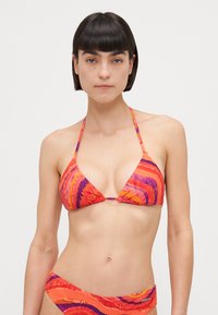 Večbarvni bikini s trikotnim vrhom in nizko rezanimi spodnjimi deli. Ima žive oranžne, roza in vijolične valove ter textured tkanino.