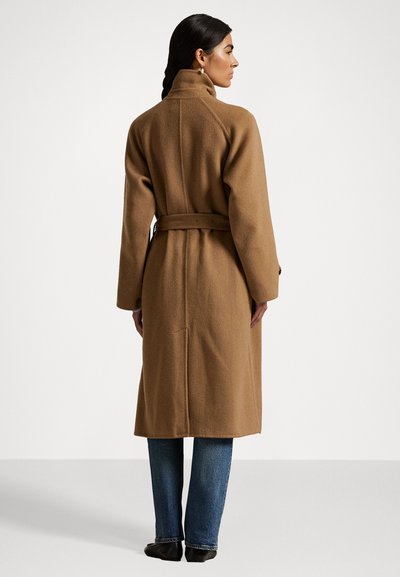 Long, belted coat made of soft, brown wool fabric. Features a high collar, long sleeves, and a minimalistic design with a back vent.