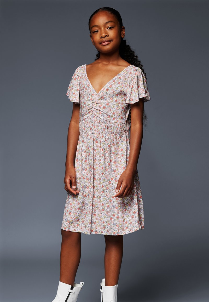 Blumenmusterkleid, kurze Schmetterlingsärmel, V-Ausschnitt, geraffte Taille, knielang. Die Farben umfassen hellrosa, grün und gelbe Akzente.