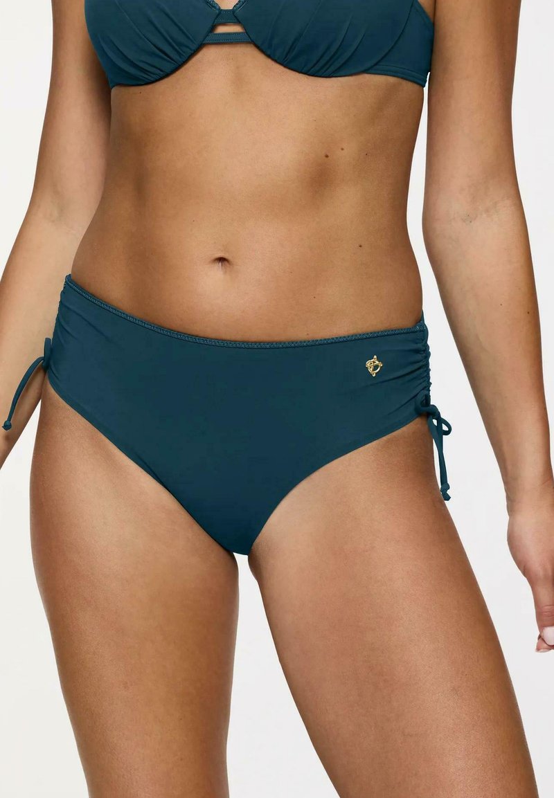 Bikini dolny w kolorze turkusowym z regulowanymi węzłami po bokach, wykonany z gładkiego materiału. Posiada subtelne marszczenia oraz małą dekoracyjną emblemat na biodrze.