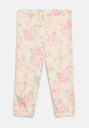 Laste kreemjas toonis fliisist dressipüksid elastsete mansettidega, roosa lillemustriga, paelaga vööjoon ja "GAP" logo vasaku reie ülaosas.