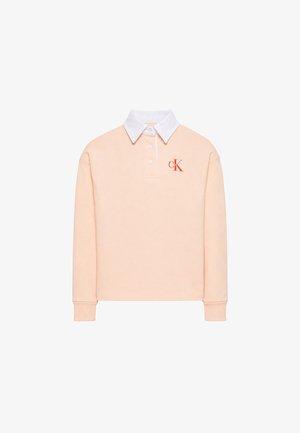Polo de manga larga color melocotón claro con cuello blanco, tres botones blancos, puños acanalados y logo rojo "cK" en el pecho izquierdo.