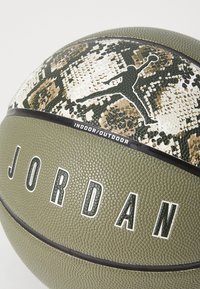 Groene basketbal met een gestructureerd oppervlak, voorzien van een slangenhuidpatroon en zwarte "JORDAN"-tekst. Ontworpen voor binnen- en buitengebruik.