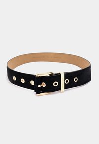 Black suede belt with gold hardware, featuring circular grommets and a rectangular buckle. Smooth interior with embossed branding.
