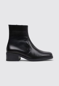 Black leather ankle boot with a pointed toe, smooth texture, and a low block heel. Minimalist design with a side zipper detail.