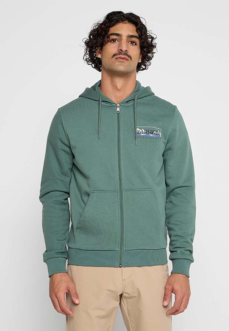 Zielona rozpinana bluza z kapturem, wykonana z teksturowanej tkaniny, z przednimi kieszeniami i naszywką z logo na klatce piersiowej. Sznurki przy kapturze, ściągacze na mankietach i u dołu.
