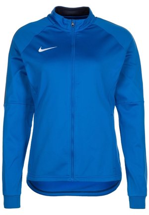 Chaqueta deportiva azul de manga larga con cremallera completa en la parte delantera y el logo blanco del swoosh de Nike en el pecho, con cuello alto y diseño ajustado.
