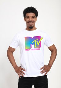 White cotton t-shirt featuring a colorful MTV logo with gradient stripes in blue, pink, and green, along with “MUSIC TELEVISION” text in pink.