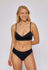 Zwart bikini-set met een bralette-top met dunne bandjes en een hoog getailleerde onderkant, gemaakt van soepel, rekbaar materiaal.