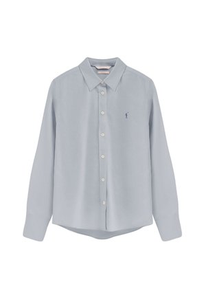 Camisa azul claro de manga larga con botones, cuello puntiagudo y pequeño logo bordado en azul oscuro en el pecho izquierdo.