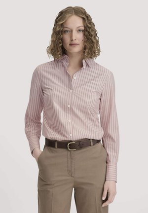 Light pink button-up shirt with vertical white stripes, long sleeves, and a classic collar, paired with khaki trousers and a dark belt.