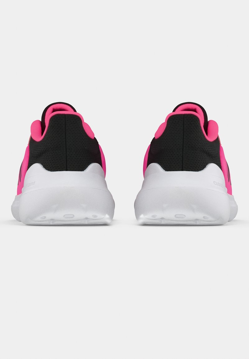 Zapatillas deportivas negras con detalles en rosa. Suela acolchada y tejido texturizado. Suela blanca lisa con patrones antideslizantes. Vista trasera.