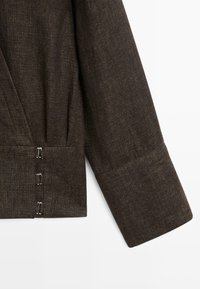 Mørkebrun tekstureret jakkesærme med tre små sølvfarvede kroge og øje-lukninger langs manchetområdet.