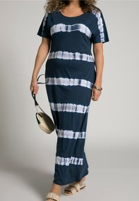 Mörkblå maxiklänning med batikmönstrade vita ränder, korta ärmar och avslappnad passform. Har mjukt, slätt tyg och rund halsringning.