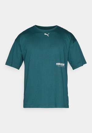 Törökzöld, rövid ujjú póló puha anyagból. Kerek nyakkal és fehér logóval a bal oldalon. Egyszerű dizájn, laza szabás.