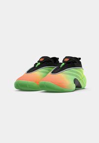 Sportssko i sort, grøn og orange gradient med en mesh-overdel, rund tå og gummisål; har en løkke og lynlås-lukning.