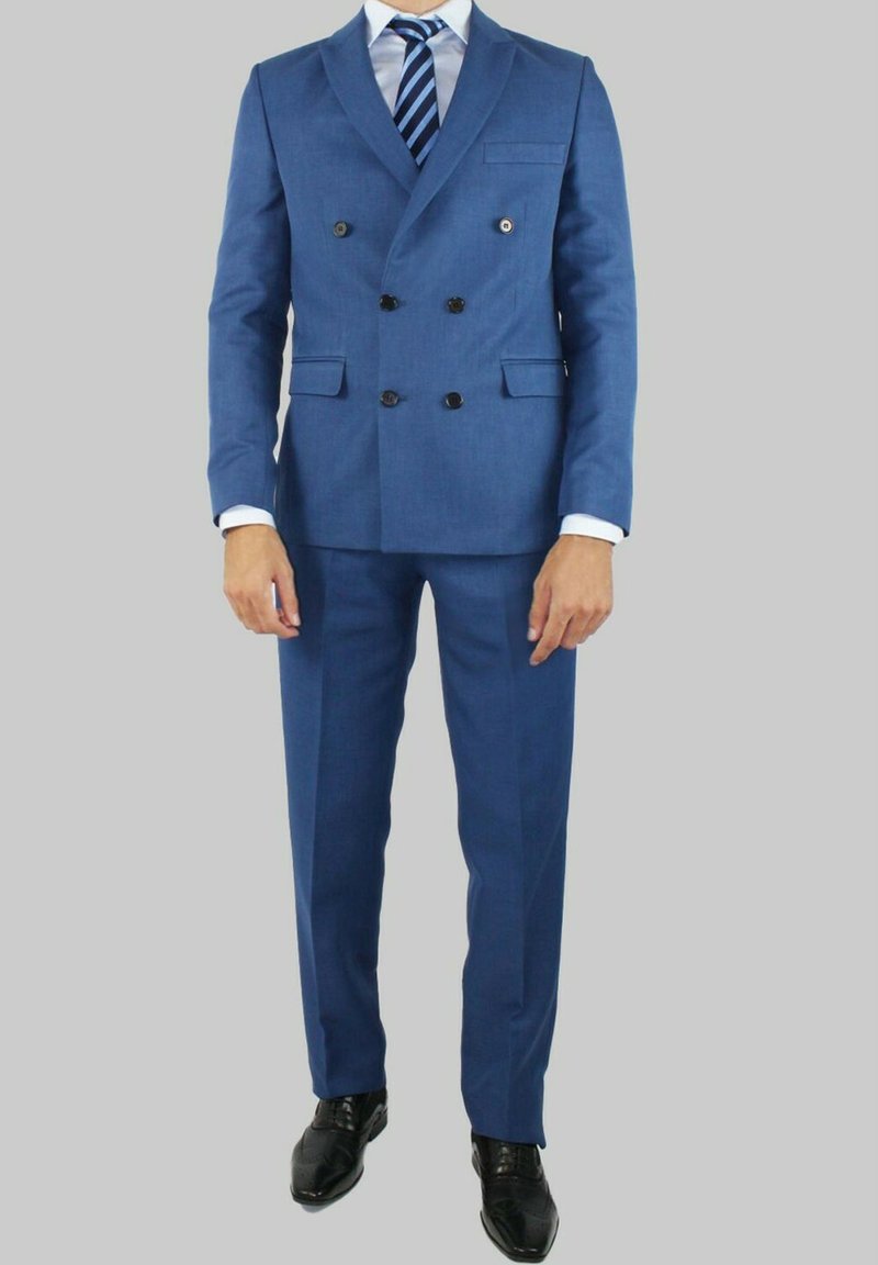 Costume bleu à double boutonnage en tissu texturé, avec des boutons noirs, des revers crantés et un pantalon assorti, complété par une cravate rayée.