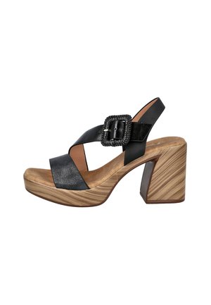 Sandalia de cuero negro con correas anchas, hebilla tejida, plantilla acolchada color beige y tacón grueso con textura de veta de madera.