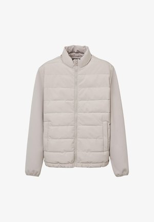 Helles beiges gesteppte Jacket mit vollem Reißverschluss auf der Vorderseite, Stehkragen, langen Ärmeln und seitlichen Taschen, auf weißem Hintergrund präsentiert.